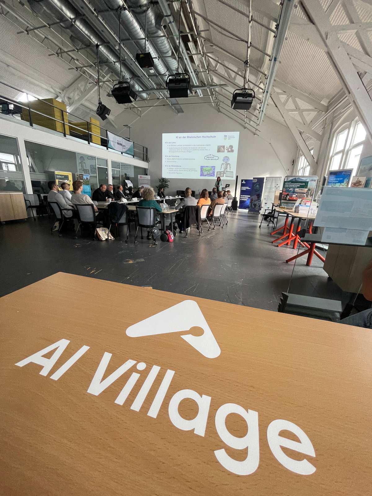 Veranstaltungsort des Fachsymposiums war hauptsächlich das AI Village, der Innovationscampus für Künstliche Intelligenz in Hürth. Das AI Village ist ein vom Bundesministerium für Wirtschaft und Klimaschutz gefördertes Verbundprojekt von Rheinischer Hochschule Köln, Stadt Hürth, Fraunhofer IAIS, KI-NRW und KI-Bundesverband im Rahmen des Strukturwandels im Rheinischen Revier