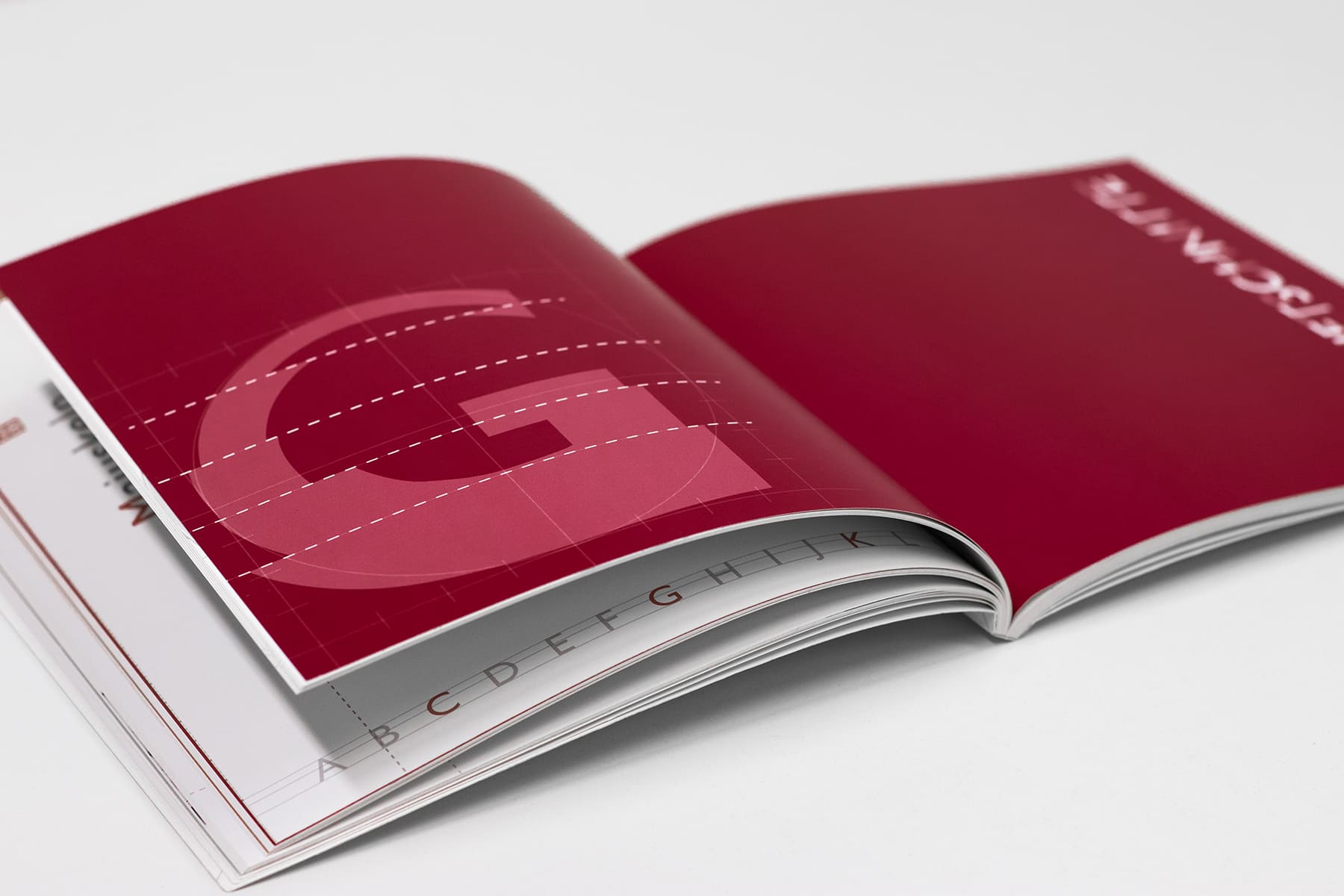 Aufgeschlagenes Buch mit roten Hintergrund. Links weiße gestrichelte Linien mit einem großem G in hellerem Rot
