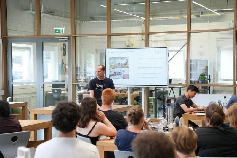 Foto: Schüler*innen im Poolhaus mit Prof. Mader