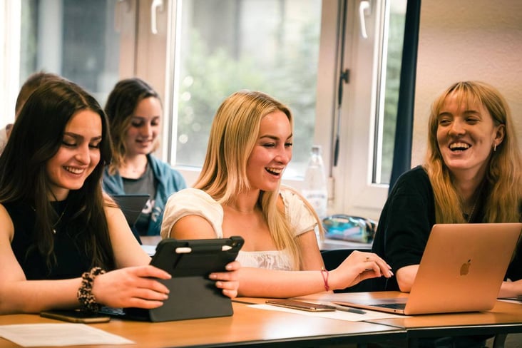 Foto Studentinnen im Hörsal mit Tablets und Unterlagen