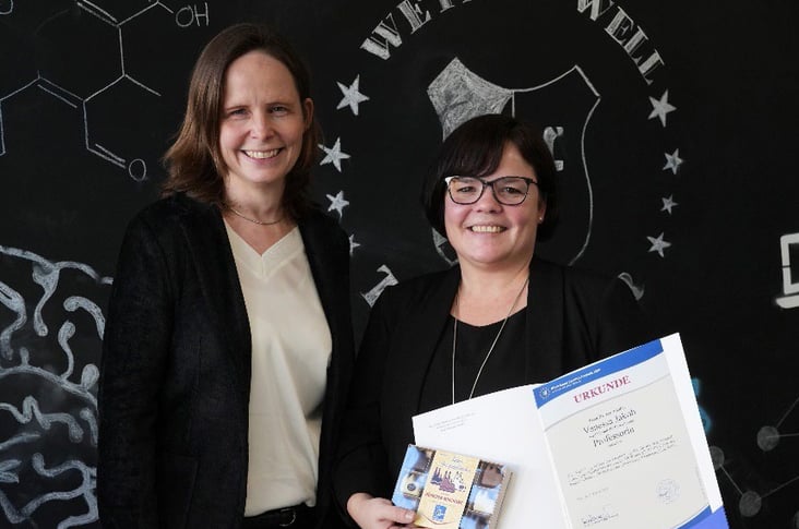 Foto: Claudia Bornemeyer überreicht Vanessa Jakob die Professor:innen-Urkunde